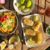 mexican corn elote on table with nachos and limes